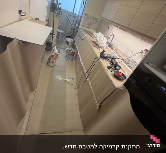 מטבח במהלך עבודות שיפוץ עם כלי עבודה והגנה על המשטחים